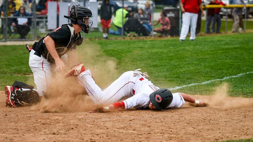 Madison catcher Cameron Svarda tags out Carlisle’s Adam Goodpaster on an attempted steal of home in the first inning Wednesday at Carlisle’s Sam Franks Field. The game was suspended and is scheduled to be finished Thursday. NICK GRAHAM/STAFF
