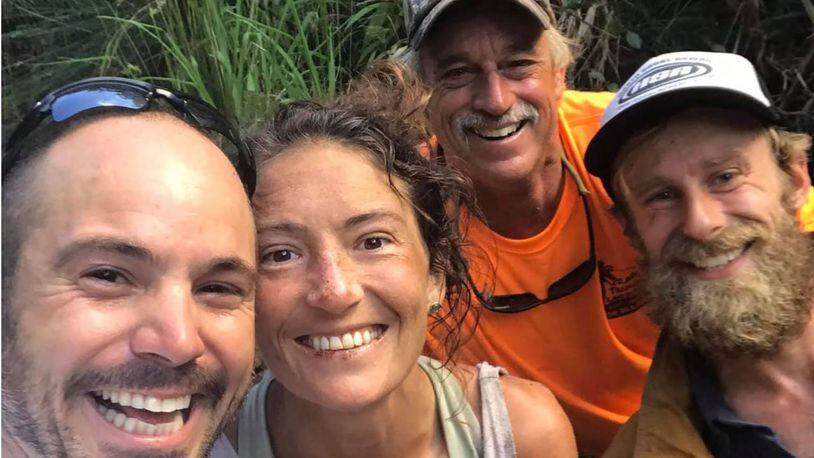 Amanda Eller smiles with Javier Cantellops, left, Troy Helmer and Chris Berquist after she was found after going missing for more than two weeks in a Hawaii reserve.