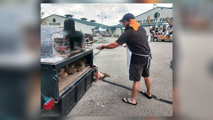 Michael Manning, 45, owner of Pizza Cicerone in Fairfield, prepares pizza in his wood-oven during a food festival at the Greene County Fairgrounds. Pizza Cicerone recently opened inside Swine City Brewery on Industry Drive. SUBMITTED PHOTO