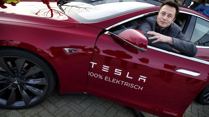 Elon Musk, co-founder and CEO of American electric vehicle manufacturer Tesla Motors, poses with a Tesla during a visit to Amsterdam on January 31, 2014. The European Tesla Service is based in Tilburg and the European headquarters is in Amsterdam. AFP PHOTO / ANP/ JERRY LAMPEN 
--NETHERLANDS OUT--        (Photo credit should read JERRY LAMPEN/AFP/Getty Images)