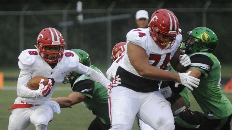 Fairfield’s Juthan McClain (with ball) follows the lead block of Jack Carman during a game at Northmont on Sept. 1. The host Thunderbolts won 28-21. MARC PENDLETON/STAFF