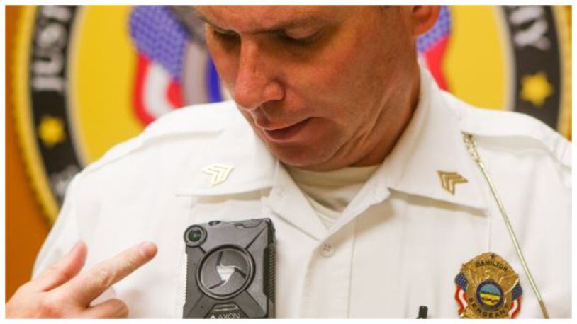 Sgt. Brian Robinson of the Hamilton Police Department displays an Axon body camera, one of several different cameras the department has tested. STAFF FILE/2016