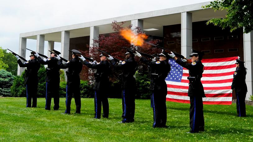 The Middletown Division of Police Honor Guard fires a 21-gun salute during the 2012 police memorial ceremony at Woodside Cemetery. NICK GRAHAM/STAFF
