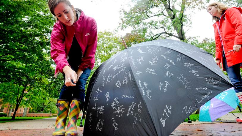 Kate Van Fossen counts signatures as she and other members of Women Against Violence and Sexual Assault try to get signatures on an umbrella to raise awareness for the Rape, Abuse and Incest National Network (RAINN) during RAINN Day 2012 Thursday, Sept. 27, on the Miami University campus in Oxford. RAINN Day is RAINN’s annual campaign to raise awareness and educate students against sexual violence on college campuses. Staff photo by Nick Graham Purple - Robin Lavigna Red - Becca Pachlhofer Teal - Megan Kincaid Pink - Kate Van Fossen Black Miami shirt signing - Freshman Kelsey Martiniez Pink boots signing - Senior Molly Kenney
