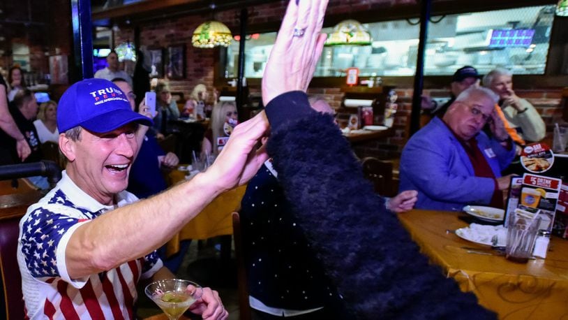 Mark Welch high-fives his wife Karen as a state is called in Donald Trump’s favor as they gather with other members of the Butler County Republican Party during an elections results watch party Tuesday, Nov. 8 at Uno Pizzeria and Grill in West Chester Township. NICK GRAHAM/STAFF