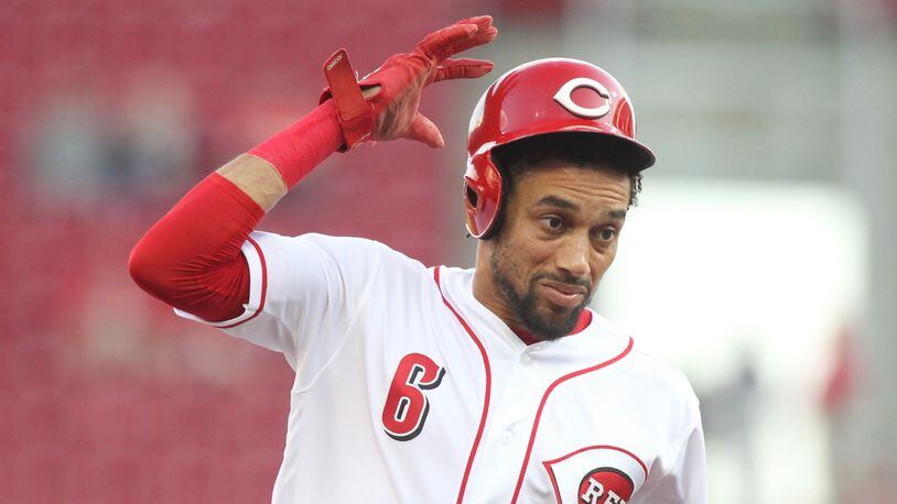 The Reds Billy Hamilton tries to hold onto his helmet as he runs to third base against the Cardinals on Thursday, April 12, 2018, at Great American Ball Park in Cincinnati. David Jablonski/Staff