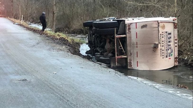 Officials said a crumbling road caused a garbage truck to fall into a creek.