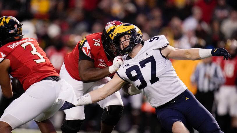 Maryland offensive lineman Delmar Glaze (74) blocks Michigan defensive end Aidan Hutchinson (97) as he tries to rush in on quarterback Taulia Tagovailoa (3) during the first half of an NCAA college football game, Saturday, Nov. 20, 2021, in College Park, Md. (AP Photo/Julio Cortez)