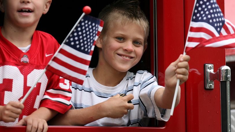 Kids wave from a fire truck during past Fourth of July parade on Verity Parkway in Middletown. FILE