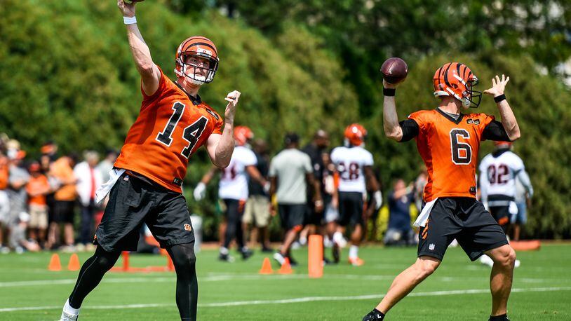 Quarterbacks Andy Dalton (14) and Jeff Driskel (6) pass the ballduring the first day of Cincinnati Bengals Training Camp Friday, July 28 at the practice fields beside Paul Brown Stadium in Cincinnati. NICK GRAHAM/STAFF