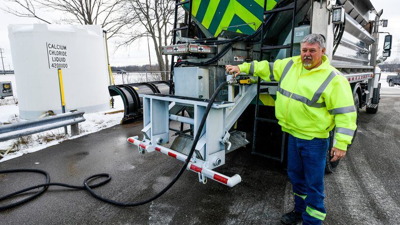 Johnny Jaco, crew leader with the Ohio Department of Transportation, demonstrates how they fill salt truck tanks with calcium chloride to help with the melting process as temperatures dip well below freezing. NICK GRAHAM/STAFF
