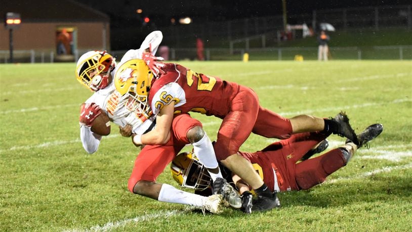 Fenwick’s Logan Miller (26) and Carter Earls bring down Purcell Marian’s Da’Montay Everett on Friday night at Krusling Field in Middletown Fenwick won 31-14. CONTRIBUTED PHOTO BY ANGIE MOHRHAUS