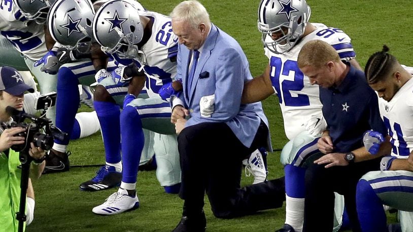 In this Monday, Sept. 25, 2017, file photo, the Dallas Cowboys, led by owner Jerry Jones, center, take a knee prior to the national anthem before an NFL football game against the Arizona Cardinals in Glendale, Ariz. What began more than a year ago with a lone NFL quarterback protesting police brutality against minorities by kneeling silently during the national anthem before games has grown into a roar with hundreds of players sitting, kneeling, locking arms or remaining in locker rooms, their reasons for demonstrating as varied as their methods. (AP Photo/Matt York, File)