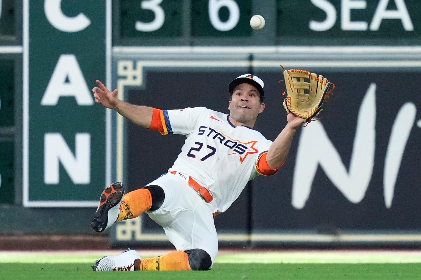 Houston Astros left fielder Jose Altuve (27) makes a sliding catch on a line drive hit by Los Angeles Angels' Kyren Paris during the ninth inning of a baseball game Sunday, April 13, 2025, in Houston. (AP Photo/Kevin M. Cox)