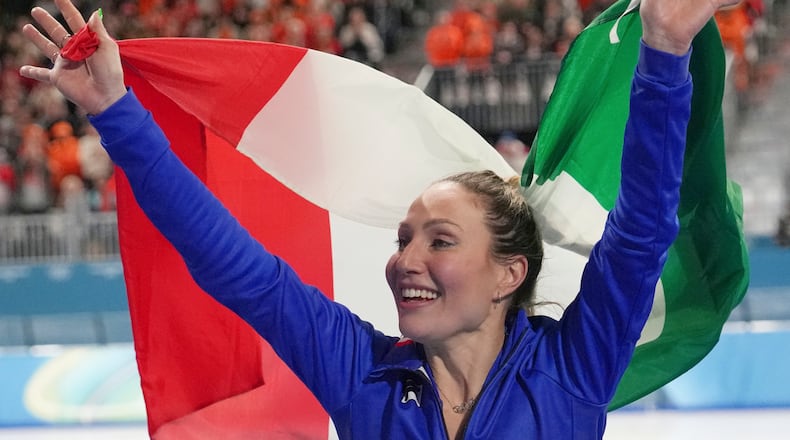 Gold medallist Francesca Lollobrigida of Italy celebrates with the Italian flag after the women's 3,000 meters speedskating race at the 2026 Winter Olympics, in Milan, Italy, Saturday, Feb. 7, 2026. (AP Photo/Christophe Ena)