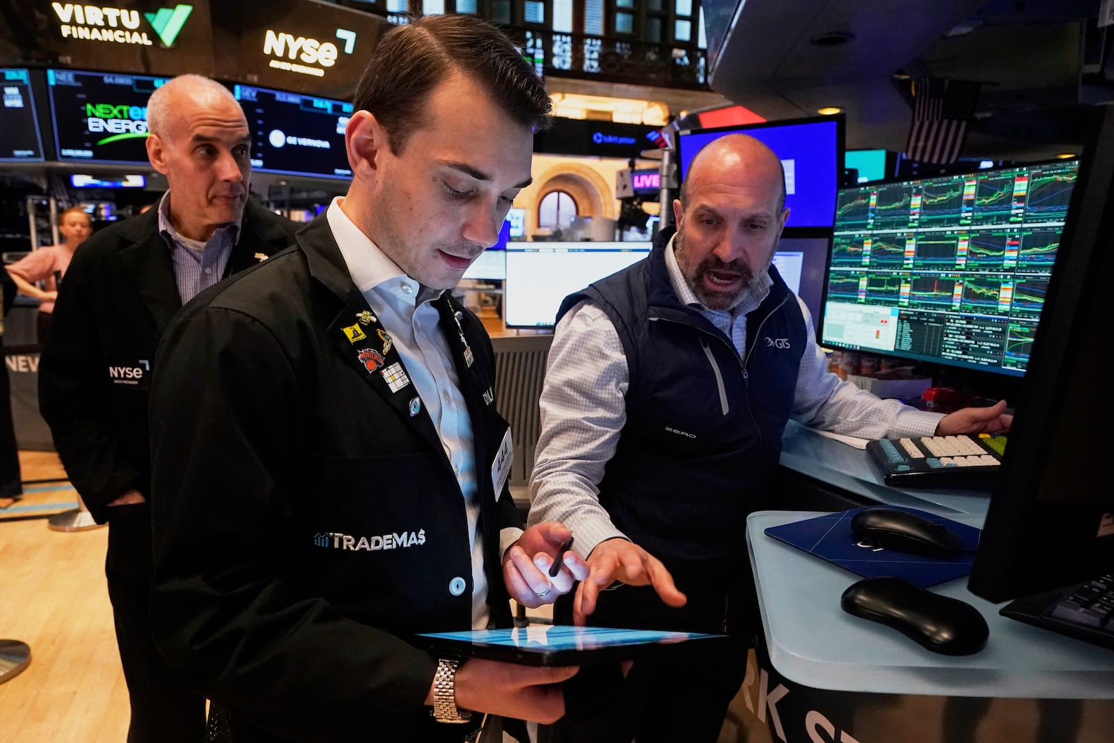Specialist James Denaro, right, and trader Dylan Halvorsan, center, work on the floor of the New York Stock Exchange, Tuesday, April 22, 2025. (AP Photo/Richard Drew)