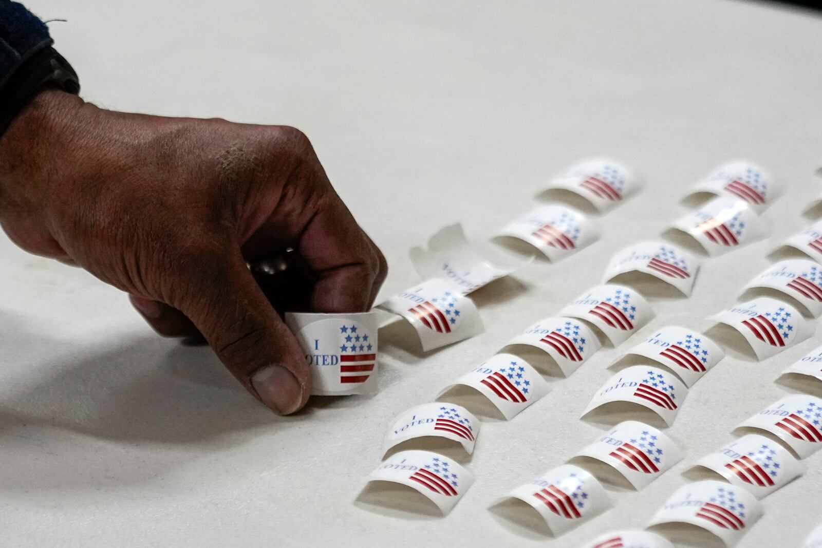 FILE - A voter picks up a sticker after voting at a polling place, March 5, 2024, in Nashville, Tenn. (AP Photo/George Walker IV, File)