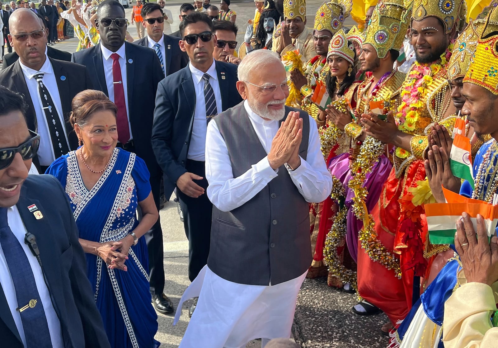 India's Prime Minister Narendra Modi greets people alongside Trinidad and Tobago's Prime Minister Kamla Persad-Bissessar, left, dressed in traditional Indian, at Piarco International Airport in Piarco, Trinidad and Tobago, Thursday, July 3, 2025. (AP Photo/Jermaine Cruickshank)