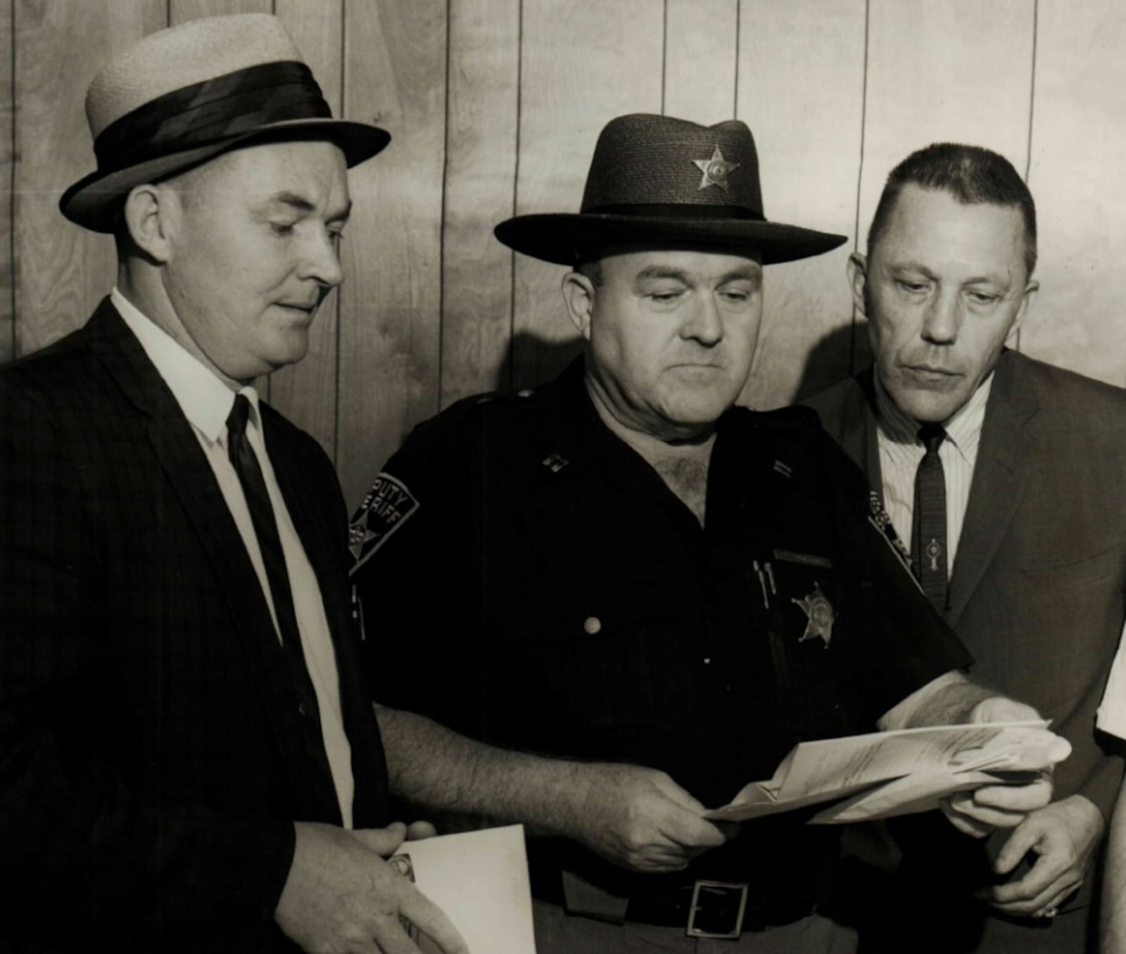 Auctioneer Harold Vaughn, Captain Thomas Begley and Butler County Sheriff James Hixon look on in the Anthony Wayne Hotel lobby on June 26, 1964 as the first auction of the property fails with no bidders. CONTRIBUTED/Butler County Historical Society