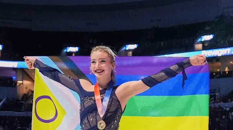 Gold medalist Amber Glenn poses with a flag after the women's free skating competition at the U.S. Figure Skating Championships, Friday, Jan. 9, 2026, in St. Louis. (AP Photo/Stephanie Scarbrough)