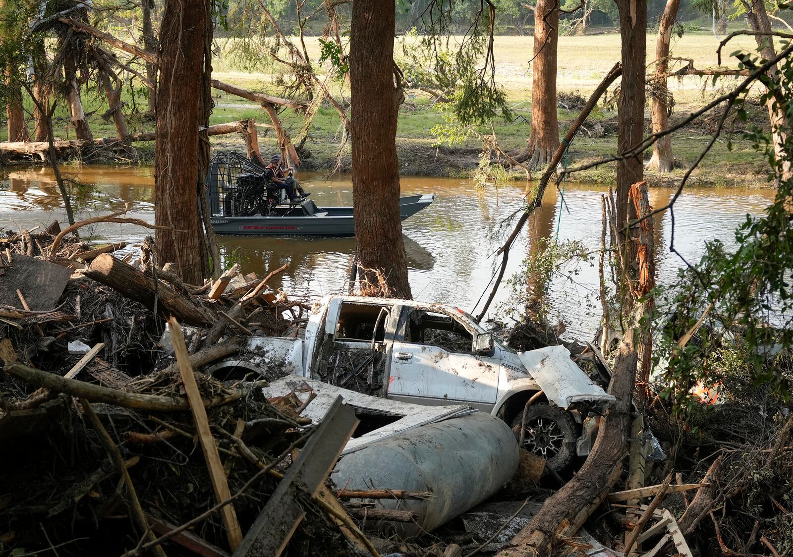 First responders on an airboat do search and recovery work on the Guadalupe River in Ingram, Texas, Tuesday, July 8, 2025, after the Fourth of July flood. (Jay Janner/Austin American-Statesman via AP)