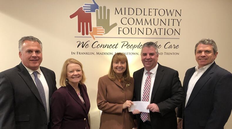 Fred DeBiasi, former president and CEO of American Savings Bank and president and COO of Valley Central Bank, presents a $100,000 check to Traci Barnett, executive director the Middletown Community Foundation. Bank executives, from left, Ben Kessling, chairman of board, Joanna Gaynor, CEO, Barnett, DeBiasi and Ed Pokora, former chairman of American Savings. RICK McCRABB/STAFF