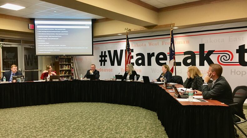 Lakota Schools Treasurer Jenni Logan (second from left) explains to board members Monday evening the projected budgetary impact of restoring 9th grade school busing the district, which eliminated all high school busing in 2011 due to sweeping budget cuts at that time. The board later voted 5-0 to provide 9th grade busing starting next school year. MICHAEL D. CLARK / STAFF
