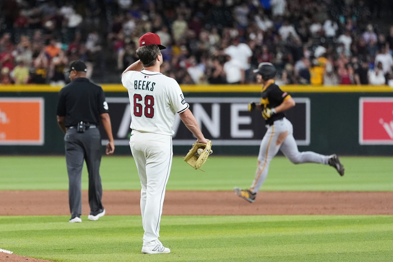 Arizona Diamondbacks pitcher Jalen Beeks (68) pauses in the infield after giving up a three-run home run to Pittsburgh Pirates' Bryan Reynolds, right, during the eighth inning of a baseball game Tuesday, May 27, 2025, in Phoenix. (AP Photo/Ross D. Franklin)