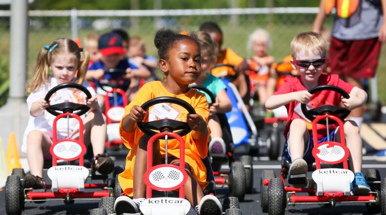 Kyndall Mckinney leads a group in their toy cars as they learn about road rules during Safety Town this week at Officer Bob Gentry Park in Hamilton. GREG LYNCH / STAFF