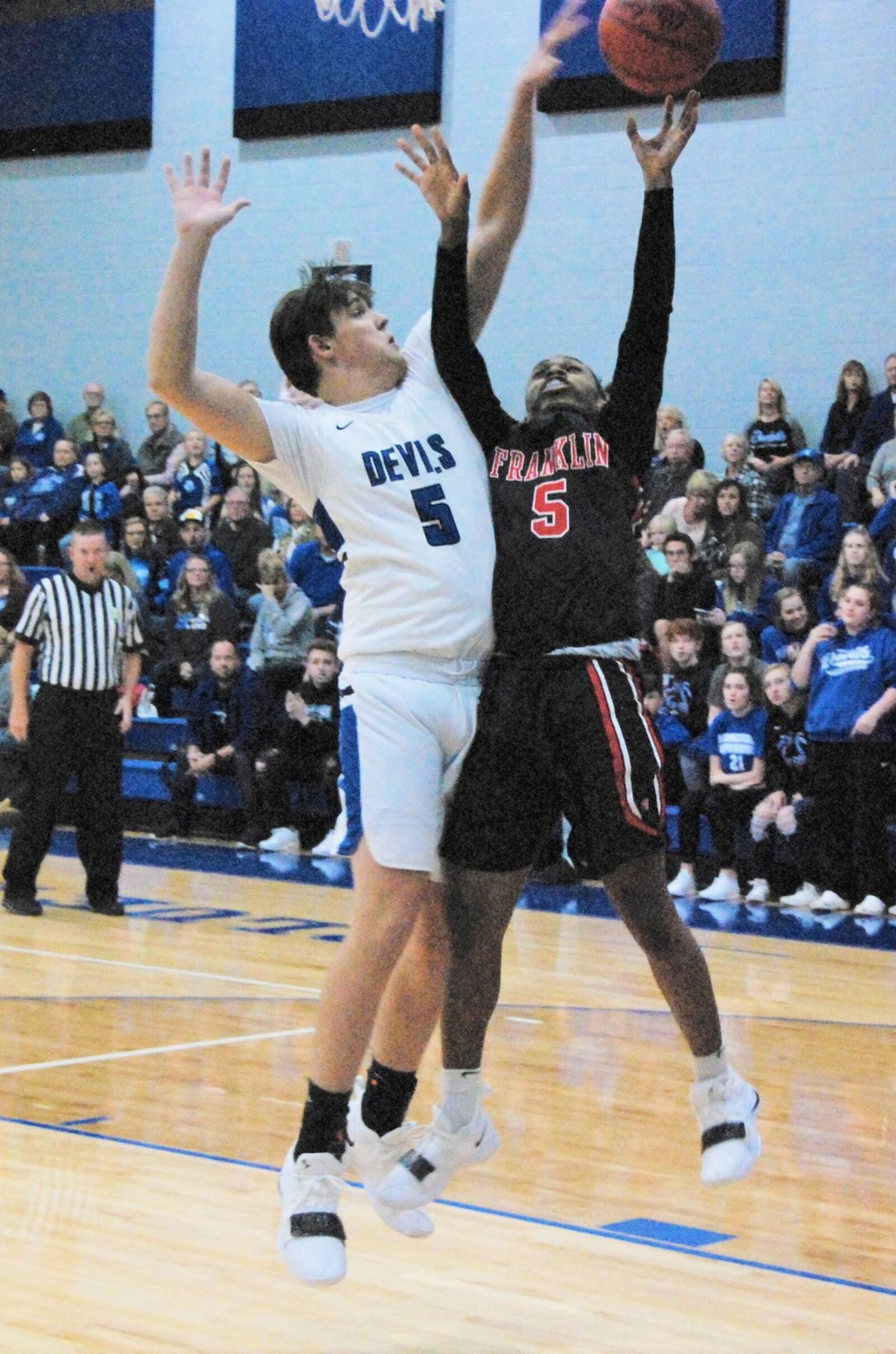 Brookville’s Weston Turner blocks a shot by Franklin’s Savon O’Neal on Friday night at Brookville. The host Blue Devils opened the season with a 75-60 win. CONTRIBUTED PHOTO BY OLIVER SANDERS