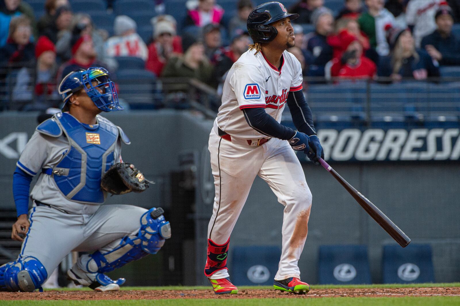 Cleveland Guardians' Jose Ramirez, right, watches his RBI sacrifice fly as Kansas City Royals' Salvador Perez, left, watches during the fifth inning of a baseball game in Cleveland, Saturday, April 12, 2025. (AP Photo/Phil Long)