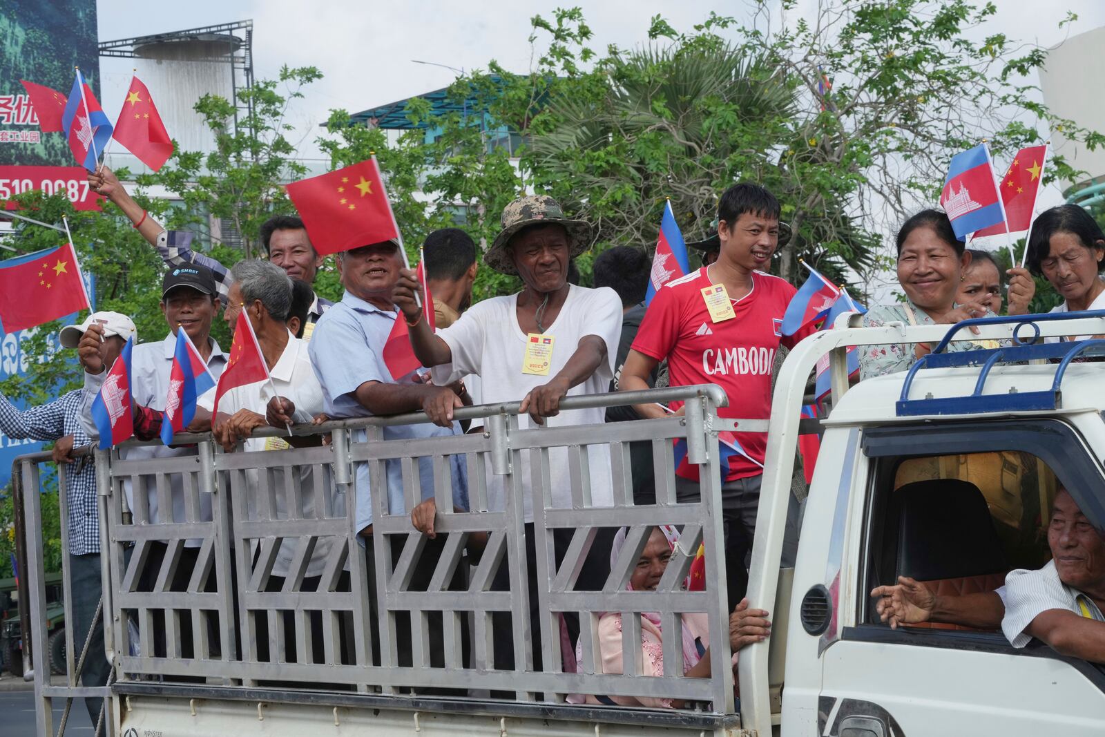 Cambodian villagers stand on a back of a truck as they arrive to welcome Chinese President Xi Jingping's arrival in Phnom Penh, Cambodia, Thursday, April 17, 2025. (AP Photo/Heng Sinith)