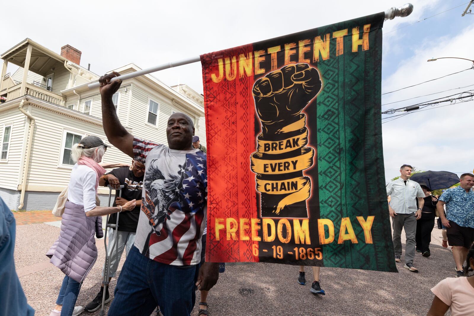 Robert Reid holds a flag during a Juneteenth celebration at the African Burying Ground Memorial Park Thursday, June 19, 2025, in Portsmouth, N.H. (AP Photo/Michael Dwyer)