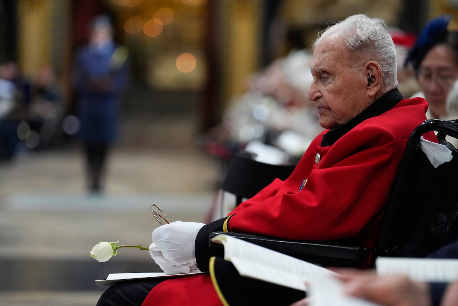 A veteran holds a white rose during a Service of Thanksgiving at Westminster Abbey on V-E Day in London, Thursday, May 8, 2025. (Jordan Pettitt/Pool Photo via AP)