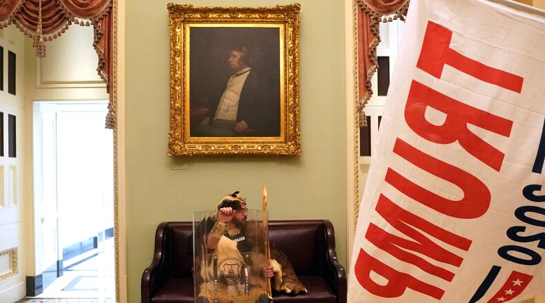 A protester with a tactical shield sits in a hallway of the Capitol in Washington on Wednesday, Jan. 6, 2020, after supporters of President Donald Trump breached security and entered the building. A mob of people loyal to President Trump stormed the Capitol on Wednesday, halting Congress’s counting of the electoral votes to confirm President-elect Joe Biden’s victory as the police evacuated lawmakers from the building in a scene of violence, chaos and disruption that shook the core of American democracy. (Erin Schaff/The New York Times)