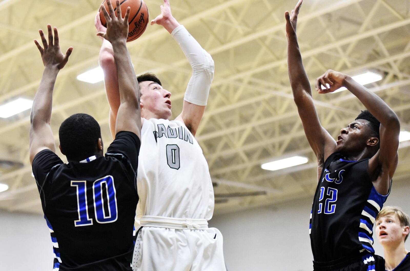 Badin’s Jakob Tipton goes up for a shot while being defended by Cincinnati Christian’s Cole Martin (10) and Josh Lawless (22) on Friday night at Mulcahey Gym in Hamilton. NICK GRAHAM/STAFF
