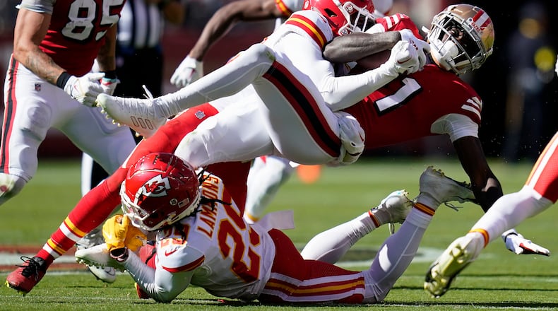 San Francisco 49ers wide receiver Brandon Aiyuk, right, is tackled by Kansas City Chiefs safety Juan Thornhill, second from top, and cornerback Chris Lammons (29) during the first half of an NFL football game in Santa Clara, Calif., Sunday, Oct. 23, 2022. (AP Photo/Godofredo A. Vásquez)