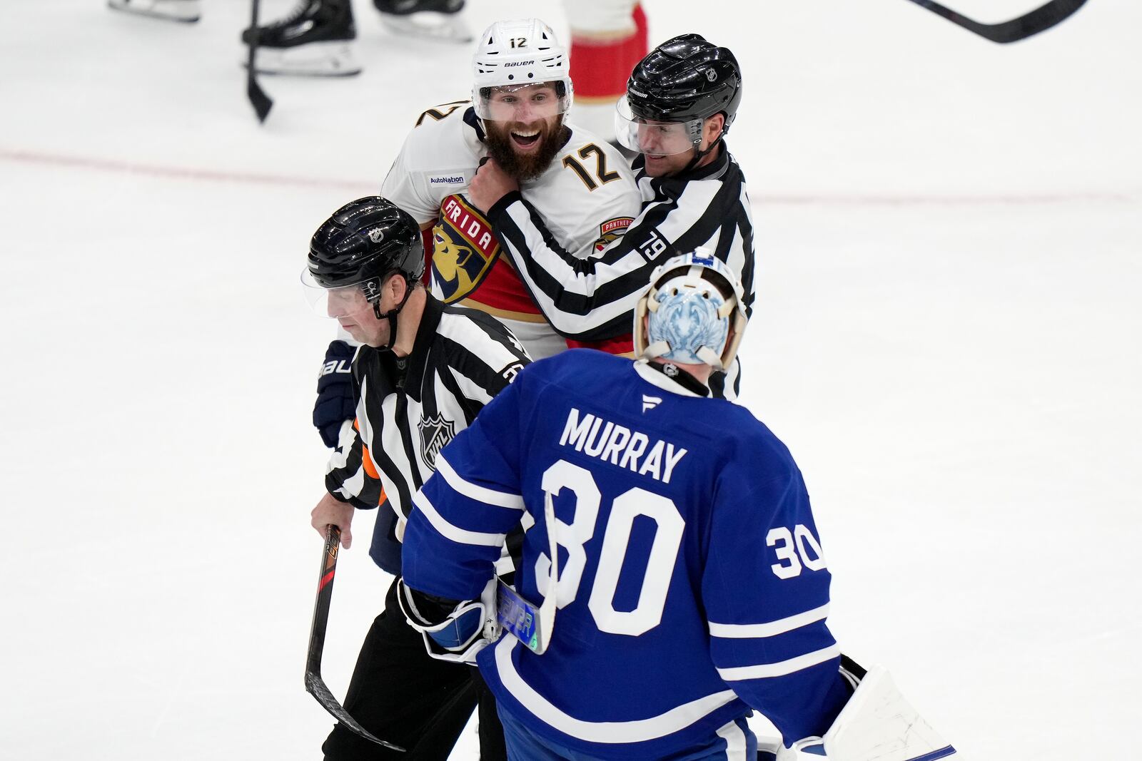 Florida Panthers' Jonah Gadjovich (12) is held back by linesman Kiel Murchison (79) as he goes after Toronto Maple Leafs goaltender Matt Murray (30) during third period NHL playoff hockey action in Toronto on Wednesday, May 14, 2025. (Frank Gunn/The Canadian Press via AP)