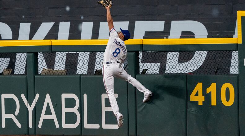 Texas Rangers left fielder Bubba Thompson makes the catch at the wall on a line drive by Philadelphia Phillies' Jake Cave during the eighth inning of an opening-day baseball game Thursday, March 30, 2023, in Arlington, Texas. (AP Photo/Jeffrey McWhorter)