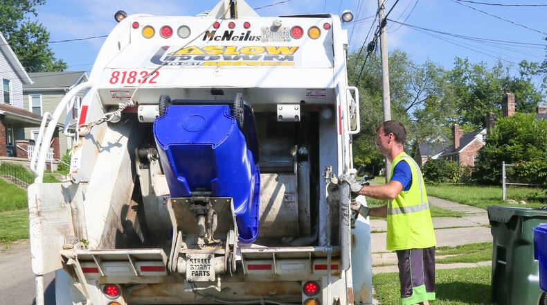 Rumpke trash collector Mike McDonald in July was busy working his route along Millikin St. GREG LYNCH / STAFF