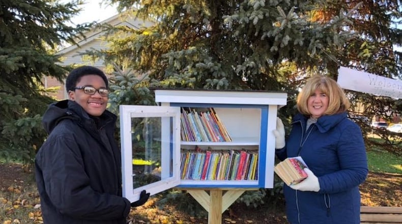 Mason Middle School eighth grader Joseph Washington and retired Mason teacher Gayle Ertel opened Little Library #1 on Nov. 10 at the corner of Tylersville Road and Foxfield Drive. CONTRIBUTED