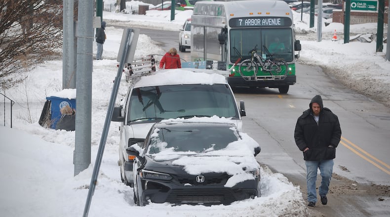 With most roads in the area and being cleared, the sidewalks still remain snow covered, causing pedestrians to have to take to the streets Wednesday, Jan. 8, 2025 like on Wyoming Street in Dayton. MARSHALL GORBY/STAFF