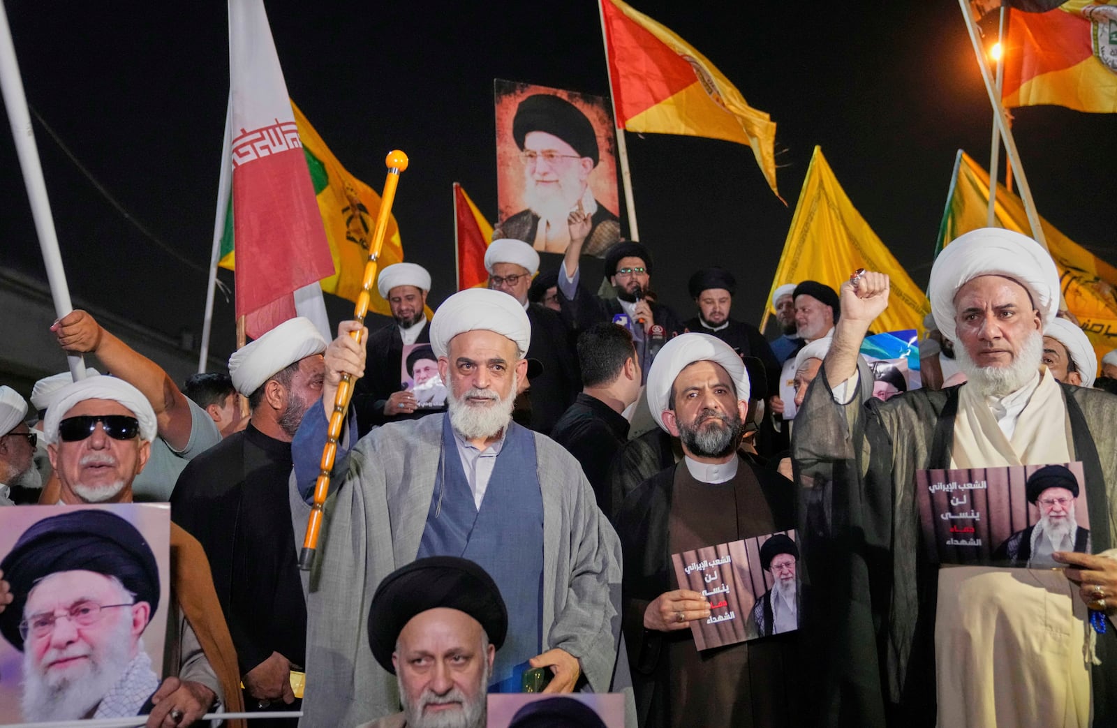 Iraqis Shiite clerics hold a portrait of Iran's Supreme Leader Ayatollah Ali Khamenei during a protest against Israeli attacks on multiple cities across Iran, at a bridge leading to the fortified Green Zone where the U.S. embassy is located in Baghdad, Iraq, Thursday, June 19, 2025. (AP Photo/Hadi Mizban)
