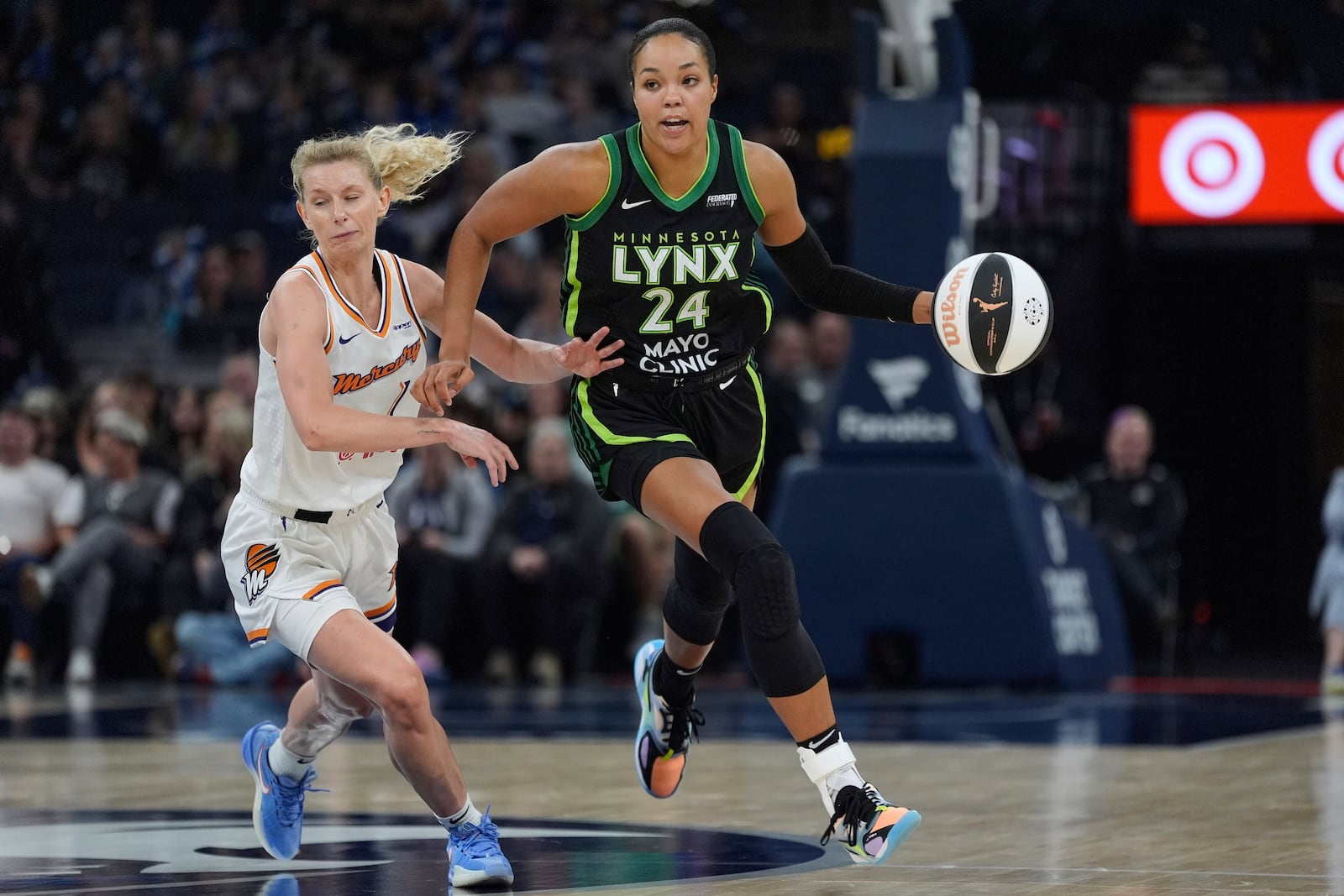 Minnesota Lynx forward Napheesa Collier (24) dribbles down the court as Phoenix Mercury guard Lexi Held (1) defends during the second half of a WNBA basketball game Tuesday, June 3, 2025, in Minneapolis. (AP Photo/Abbie Parr)
