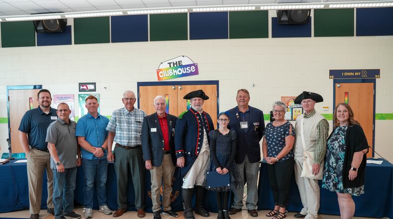 For the first time in Ohio a famous American history society has named an elementary teacher for its top annual award and she works in Monroe Schools.
Officials with the Ohio Society of the Sons of the American Revolution (SAR) recently named elementary school teacher Melissa Costello as this year’s recipient of its Dr. Tom & Betty Lawrence American History Teacher Award. From left to right: Monroe School Board Member A.J. Fullam, Board President Dave Grant, Board Member Tim Carpenter, Board Member Tom Leeds, Cincinnati SAR Member Larry Collins, Cincinnati SAR Member Bob Bowers, student winner Alexa Funke, Cincinnati SAR Member D. Scott Freeman, Melissa Costello, M. Ed., Cincinnati SAR Chapter President George Stewart and Monroe School Board Vice President Debbie Hagedorn. (Provided Photo\Journal-News)
