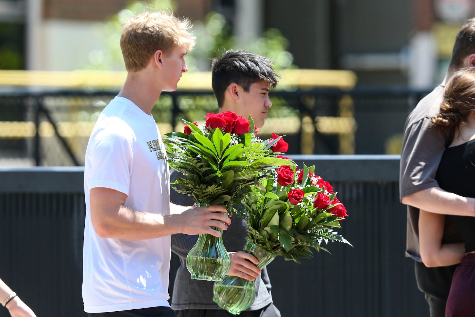 Students carry flowers near the Florida State Student Union building, Tallahassee, Fla., Friday, April 18, 2025. (AP Photo/Gary McCullough)