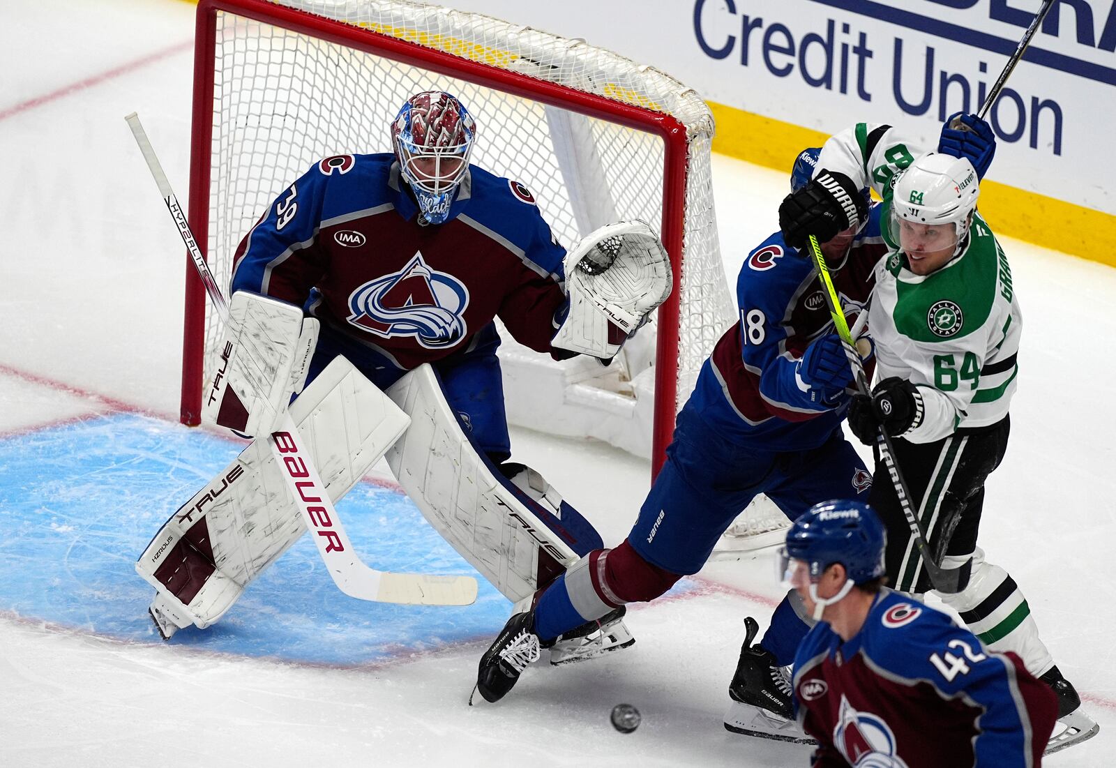 Dallas Stars center Mikael Granlund, right, struggles to redirect the puck as Colorado Avalanche defenseman Samuel Girard, center, protects goaltender Mackenzie Blackwood in the first period of Game 3 of an NHL hockey first-round playoff series Wednesday, April 23, 2025, in Denver. (AP Photo/David Zalubowski)