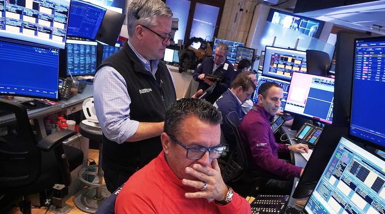 Trader Robert Finnerty Jr., foreground, works with colleagues on the floor of the New York Stock Exchange, Monday, Jan. 12, 2026. (AP Photo/Richard Drew)