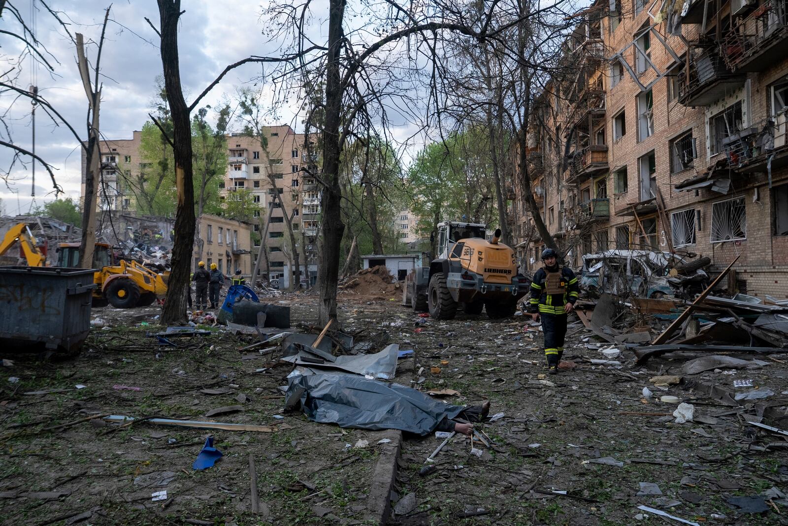 A rescue worker passes the body of a victim after a Russian strike in a residential neighborhood in Kyiv, Ukraine, Thursday, April 24, 2025. (AP Photo/Alex Babenko)