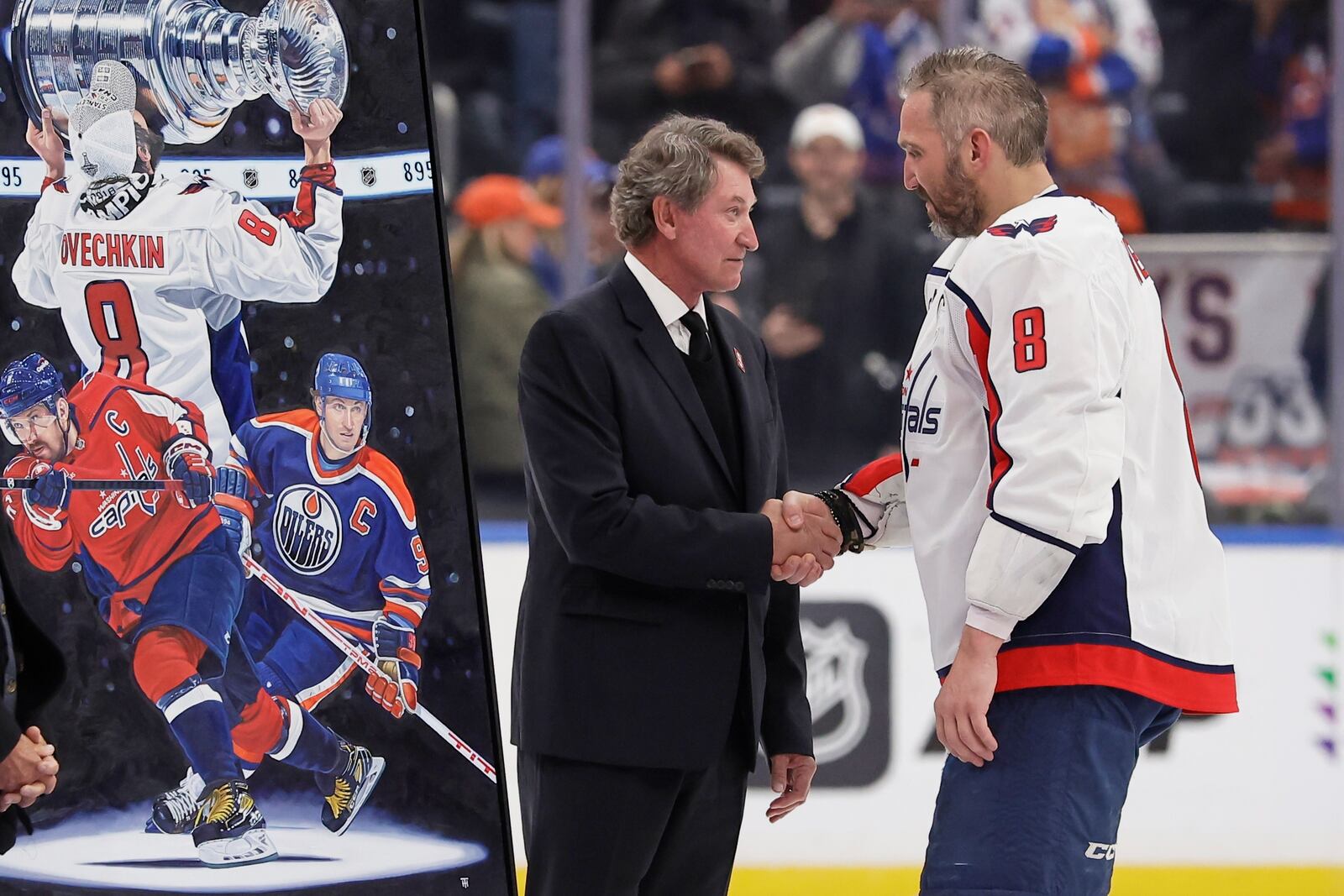 Washington Capitals left wing Alex Ovechkin (8) is greeted by Wayne Gretzky during a ceremony after he scored his 895th career goal during the second period of an NHL hockey game against New York Islanders in Elmont, N.Y., Sunday, April 6, 2025. (AP Photo/Adam Hunger)
